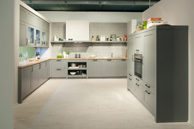 Offene Wohnküche in einem hellen Grau und mit viel Stauraum