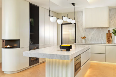 Example of a mid-sized trendy light wood floor eat-in kitchen design in Toronto with white cabinets, marble countertops, white backsplash, marble backsplash, paneled appliances, an island and white countertops