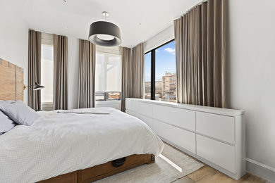 Foto de dormitorio minimalista sin chimenea con suelo de madera en tonos medios y suelo marrón