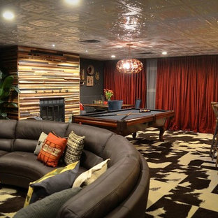 Photo of a large bohemian walk-out basement in Atlanta with green walls, carpet and a standard fireplace.