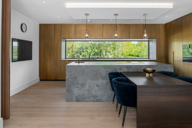 Contemporary galley open plan kitchen in Other with a built-in sink, flat-panel cabinets, brown cabinets, granite worktops, coloured appliances, porcelain flooring, an island, brown floors and grey worktops.