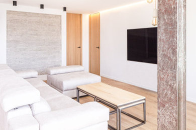 Imagen de salón abierto y gris y blanco minimalista de tamaño medio con paredes blancas, suelo vinílico, televisor colgado en la pared, suelo marrón y bandeja