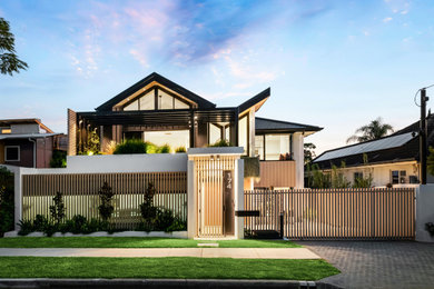 Design ideas for a large contemporary three-storey concrete white house exterior in Brisbane with a butterfly roof, a tile roof and a black roof.