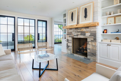 Beach style light wood floor living room photo in Other with white walls, a standard fireplace and a stone fireplace