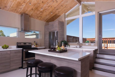 Eat-in kitchen - mid-sized contemporary l-shaped ceramic tile eat-in kitchen idea in San Francisco with a single-bowl sink, flat-panel cabinets, medium tone wood cabinets, quartz countertops, beige backsplash, stone slab backsplash, stainless steel appliances and an island