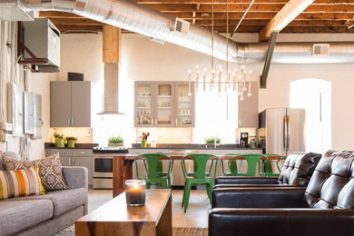 Example of an urban galley open concept kitchen design in Milwaukee with flat-panel cabinets and gray cabinets