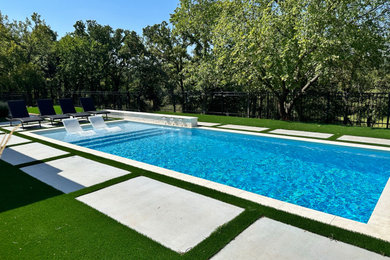 Foto de piscina moderna grande rectangular en patio trasero con adoquines de hormigón