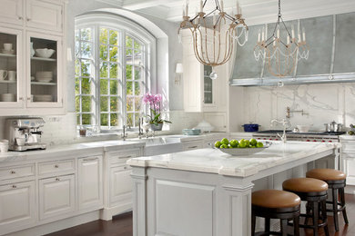 Example of a large transitional dark wood floor and brown floor open concept kitchen design in Chicago with a farmhouse sink, recessed-panel cabinets, white cabinets, marble countertops, white backsplash, stone tile backsplash, stainless steel appliances and an island