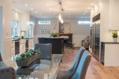 Example of a large arts and crafts medium tone wood floor and brown floor kitchen/dining room combo design in Vancouver with gray walls