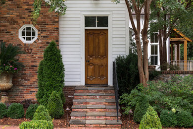 Example of a mid-sized transitional brick floor entryway design in Atlanta with white walls and a medium wood front door