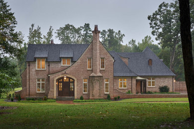 Example of a huge classic two-story brick house exterior design in Charlotte with a shingle roof