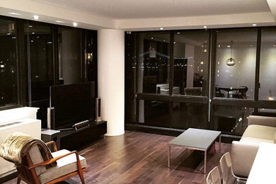 Example of a mid-sized trendy open concept dark wood floor and brown floor living room design in New York with white walls, no fireplace and a tv stand