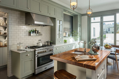 Traditional galley eat-in kitchen in San Francisco with an undermount sink, shaker cabinets, green cabinets, wood benchtops, white splashback, subway tile splashback, stainless steel appliances, dark hardwood floors and with island.