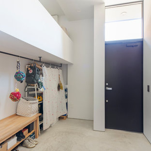 東京23区の片開きドアモダンスタイルのおしゃれなマッドルーム (白い壁、コンクリートの床、黒いドア、グレーの床) の写真