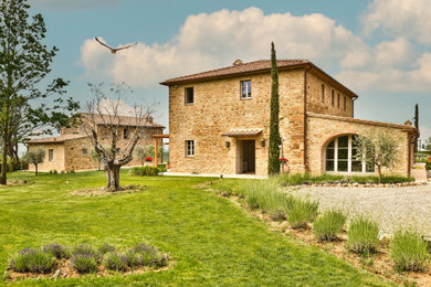 Esempio della villa grande country a due piani con rivestimenti misti, tetto a capanna, copertura in tegole e tetto rosso