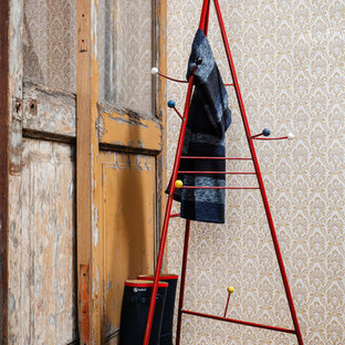 Foto på ett eklektiskt kapprum, med flerfärgade väggar, mellanmörkt trägolv, en skjutdörr och mellanmörk trädörr