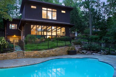This is an example of an expansive midcentury split-level brown house exterior in DC Metro with wood siding.