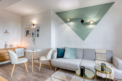 Réalisation d'un petit salon nordique fermé avec un mur vert, parquet clair, aucune cheminée, un téléviseur fixé au mur et un sol gris.