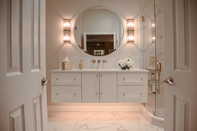 Idée de décoration pour une salle de bain principale design de taille moyenne avec un placard à porte plane, des portes de placard blanches, une baignoire indépendante, une douche d'angle, un bidet, un carrelage blanc, des carreaux de porcelaine, un mur beige, un sol en carrelage de porcelaine, un lavabo encastré, un plan de toilette en quartz modifié, un sol blanc, une cabine de douche à porte battante, un plan de toilette blanc, une niche, meuble simple vasque, meuble-lavabo suspendu et un plafond voûté.