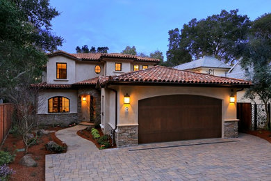 Inspiration for a mid-sized mediterranean two-storey stucco beige house exterior in San Francisco with a hip roof and a tile roof.