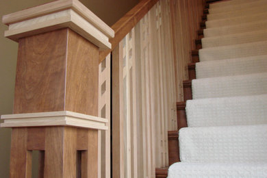 Imagen de escalera recta clásica renovada grande con escalones enmoquetados y barandilla de madera