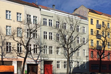 Mittelgroßes Klassisches Reihenhaus mit Putzfassade, grauer Fassadenfarbe, Satteldach und Ziegeldach in Berlin