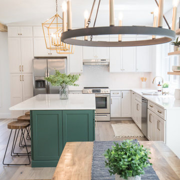 Kitchen with green island and white cabinets