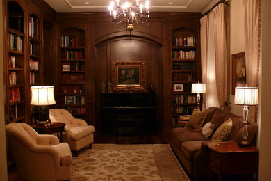 Inspiration for a large timeless open concept dark wood floor and brown floor living room library remodel in Houston with beige walls, a standard fireplace, a wood fireplace surround and no tv