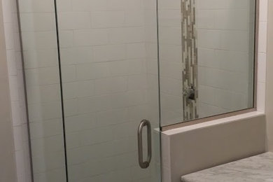 Small trendy 3/4 multicolored tile and pebble tile corner shower photo in Denver with shaker cabinets, white cabinets, beige walls, an undermount sink and marble countertops
