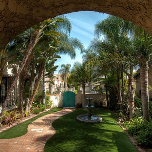 Medelhavsstil inredning av ett mellanstort beige hus, med två våningar, stuckatur, halvvalmat sadeltak och tak med takplattor