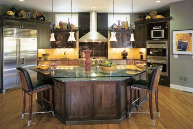 This is an example of a mid-sized traditional u-shaped separate kitchen in Cincinnati with an undermount sink, shaker cabinets, dark wood cabinets, granite benchtops, yellow splashback, stainless steel appliances, medium hardwood floors and with island.