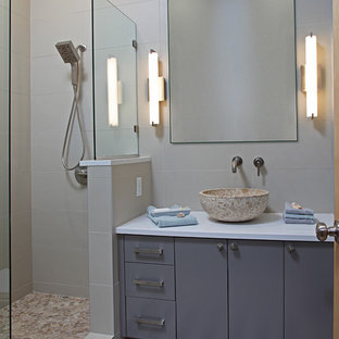 Foto di una piccola stanza da bagno con doccia moderna con lavabo a bacinella, ante lisce, ante grigie, top in quarzo composito, doccia alcova, WC monopezzo, piastrelle multicolore, piastrelle di ciottoli, pareti blu e pavimento in gres porcellanato