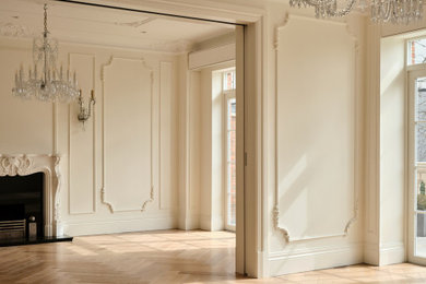 Design ideas for a large classic formal and cream and black living room in London with white walls, light hardwood flooring, a standard fireplace, a stone fireplace surround, no tv, brown floors, a coffered ceiling, panelled walls and a dado rail.