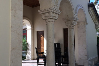 Large tuscan white stone exterior home photo in Miami