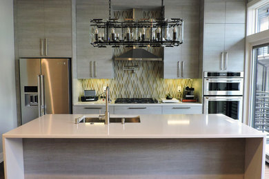 Kitchen - contemporary medium tone wood floor kitchen idea in Philadelphia with a single-bowl sink, flat-panel cabinets, light wood cabinets, quartz countertops, multicolored backsplash, mosaic tile backsplash, stainless steel appliances, an island and white countertops