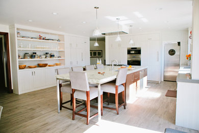 Huge transitional u-shaped porcelain tile kitchen pantry photo in Salt Lake City with a double-bowl sink, flat-panel cabinets, light wood cabinets, subway tile backsplash, stainless steel appliances and an island
