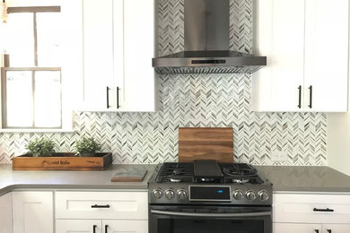 Example of a minimalist kitchen design in Atlanta with shaker cabinets, white cabinets, quartz countertops and glass tile backsplash
