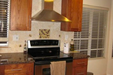 Kitchen - large kitchen idea in San Francisco with a drop-in sink, medium tone wood cabinets, granite countertops, stainless steel appliances and an island