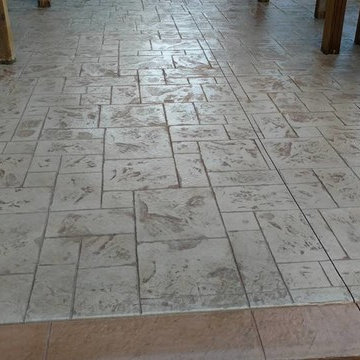 J-Stamped concrete patio with a step under the wood deck