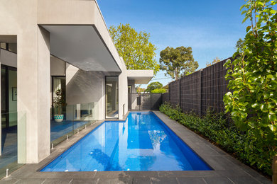 Inspiration for a contemporary l-shaped pool in Melbourne with natural stone pavers.