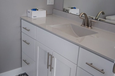 Photo of a small country ensuite bathroom in Other with shaker cabinets, white cabinets, grey walls, porcelain flooring, an integrated sink, marble worktops, grey floors and grey worktops.