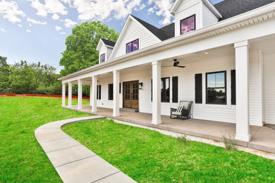 Large country stamped concrete porch photo in St Louis with a roof extension