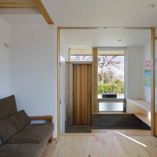 横浜の中サイズの片開きドアモダンスタイルのおしゃれな玄関 (白い壁、淡色無垢フローリング、木目調のドア、ベージュの床) の写真