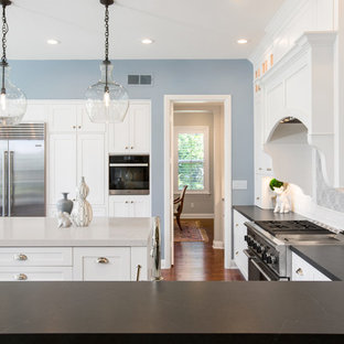 Idée de décoration pour une grande arrière-cuisine tradition en U avec un évier de ferme, un placard à porte shaker, des portes de placard blanches, un plan de travail en stéatite, une crédence blanche, une crédence en carrelage métro, un électroménager en acier inoxydable, un sol en bois foncé, un îlot central, un sol marron et un plan de travail gris.