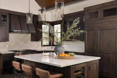 Inspiration for a large rustic l-shaped dark wood floor, brown floor and vaulted ceiling open concept kitchen remodel in Sacramento with a single-bowl sink, shaker cabinets, medium tone wood cabinets, quartzite countertops, beige backsplash, stone slab backsplash, paneled appliances, an island and beige countertops