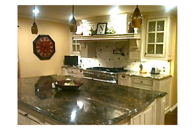 Mid-sized elegant single-wall eat-in kitchen photo in Austin with a single-bowl sink, raised-panel cabinets, white cabinets, stainless steel appliances and an island
