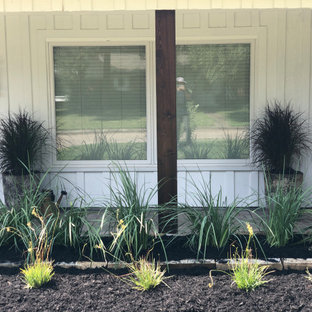 Großer Eklektischer Vorgarten mit Blumenbeet, direkter Sonneneinstrahlung und Mulch in Houston