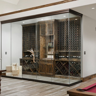 Inspiration för rustika vinkällare, med vinställ med diagonal vinförvaring och grått golv