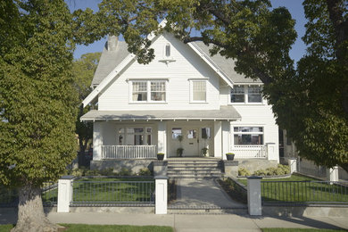 Large arts and crafts three-storey white exterior in Los Angeles with wood siding.