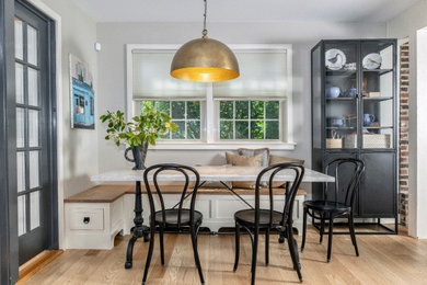 Breakfast nook - mid-sized cottage light wood floor breakfast nook idea in Philadelphia with gray walls, a standard fireplace and a brick fireplace